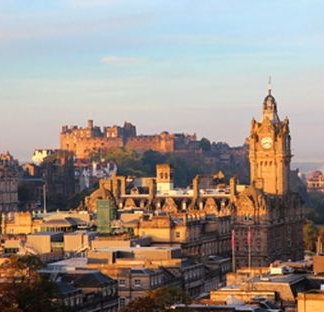 Panorama of Edinburgh at sunrise with historic skyline illuminated by early morning light